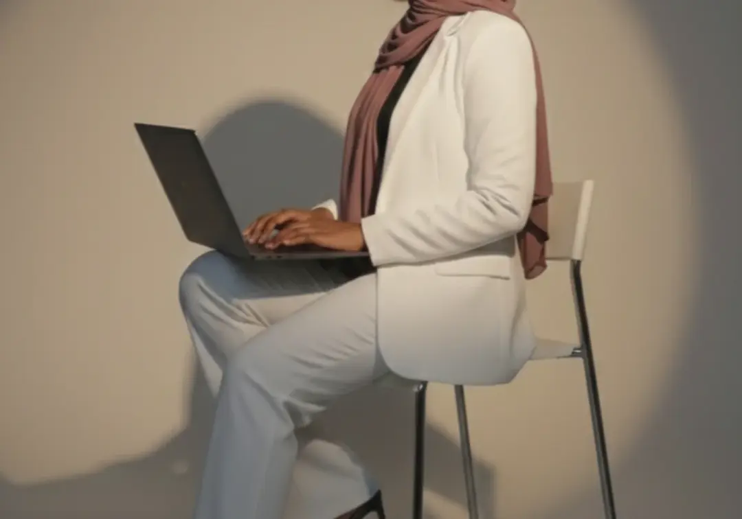 Oumou, fondatrice de Harmonie Pure, assise avec son ordinateur